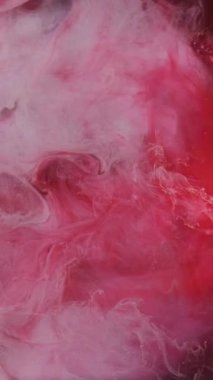 Dikey video. Boya su sıçratır. Duman dalgası. Odaklanmamış kırmızı beyaz renkli simli toz dokusu patlama buharı akışı siyah soyut sanat arka planında hareketi ortaya çıkarıyor.