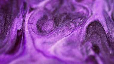 Sıvı partiküller dökülür. Mürekkep karışımı. Odaklanmamış mor renkli parıldayan desen boyası karışık hareket soyut sanat arkaplanı.