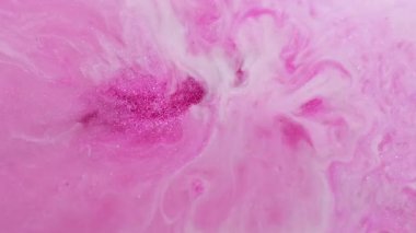 Parlak karışım. Parıltı seli. Parlak pembe metal tozları parlatıcı sıvının içinde. Sanat dekoratif tuhaf akış lüksü soyut bir arkaplanı ateşliyor.