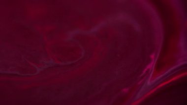 Odaklanamayan sıvı dökülmesi. Boya sıçraması. Bulanık neon pembe mor duman dokusu parlayan mürekkep akışı koyu soyut sanat arkaplanı.