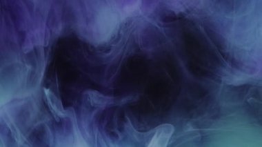 Süzülen bir sis. Mürekkep suyu karışımı. Neon mavisi mor renk patlama dumanı yüzen doku dalgası hareket soyut arkaplan yayıyor.