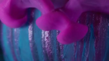 Mürekkep akıyor. Emülsiyon damlası. Pembe mor duman soyut mavi küre akıyor, parıldıyor, çizgili yüzey, su çözünmüş arka plan..