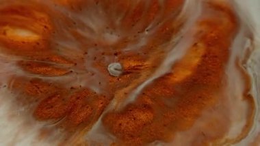 Lav mürekkebi. Boya çiçeği. Turuncu bakır metal toz sıvısı beyaz diş minesi sıvı yüzeyine yayılmış. Yuvarlak lekeler, soyut sanat geçmişi..