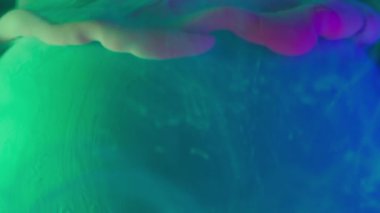 Boya lekesi. Mistik duman. Renkli sisli mat sıvısı oval toz kürenin üzerine şeffaf soyut bulanık su arka planında yumuşak düşüyor.