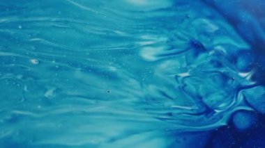 Pigment karışımı. Boya akışı. Mavi mermer genişleme sıvı yüzeyi. Odaklanmamış kabarcık sıçraması beyaz ıslak soyut arkaplan üzerine yayılır.