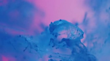 Su damlaları. Boya akışı. Odaklanamayan parlak mavi parlak sıvı dumanlı bulutlar soyut pembe ışık sanat arka planında.