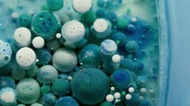 Akrilik baloncuk. Boya karışımı. Renkli jel damlaları su yüzeyinde saydam yuvarlak noktalarda yüzer. Fantezi mavisi soyut sıvı arkaplan.