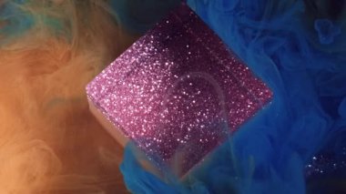 Soyut geometrik. Mürekkep karışımı. Parlak sarı çok renkli duman rengi boya dokusu ışıl ışıl parıldayan küp bulut sanat mor parıltılı ışık arka planında yüzüyor.