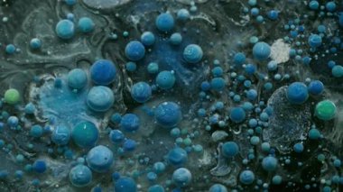 Sanat sıvısı. Kabarcık mürekkebi. Yüzen mavi jel damlalarını karıştıran mistik mermer gri siyah su. Dalgalı akan bulanık renkli soyut arkaplan.