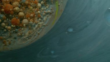 Renkli sıvı. Mermer baloncuklar. Mavi gri akarsu, dönen yağ çemberi. Soyut duman arka planında izole turuncu bej mürekkep damlaları.