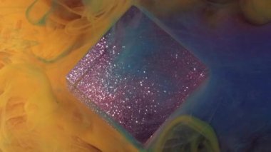 Karışık ton. Boya dökülmüş. Parlak sarı renkli akış duman kübü simli bulut mürekkebi deseni soyut sanat ışığı arka planında yüzüyor..