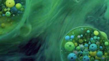 Sis sıvısı. Kabarcık boyası. Şeffaf yağ çemberleri mermer üzerinde yüzen renkli köpük mürekkep düşürür. Titreyen su soyut arka plan yüzeyi..