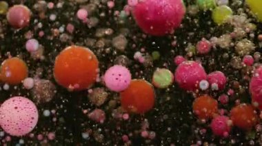 Emülsiyonu bırak. Sabun boyası. Işıldayan suyun içinde yüzen yuvarlak köpük baloncukları. Yaratıcı sıvı parçacıkları soyut arkaplan.