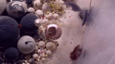 Pırıl pırıl. Kabarcık boyası. Işıldayan gümüş akışı boya köpüklü yağ damlalarını karıştırıyor. Soyut parçacıklar çözünmüş su arkaplanı.