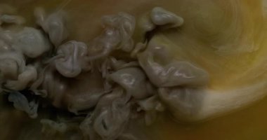 Sigara arkaplanı. Buhar bulutu. Odaklanmamış sarı bronz mor renk akrilik soyutlamada büyüyen suda boya sıçratıyor..