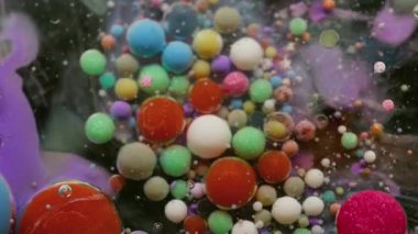 Boya sıvısı. Mürekkep akışı. Yağlı boya damlaları suda eriyor. Renkli akrilik pigment köpük yüzen soyut sanat arkaplanı.