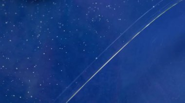 Yağ mürekkebi suyu. Yüzen boya. Boyayı küçük parçacıklarla renkli sıvıya düşürür. Sanat mavisi sıvı çözünmüş ışıltılı sis soyut arkaplan dokusu.