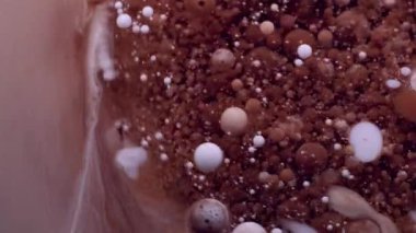 Jel damlası. Boya karışımı. Yağlı boya damlaları suda eriyor. Kahverengi bej beyaz pigment soyut bulanık sanat arkaplanı.