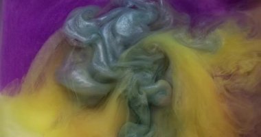 Dönen mürekkep. Su altı patlaması. Bulanık, mavi, sarı, renkli, parlak, parlak doku soyut arkaplanda yayılıyor..