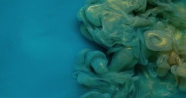 Parıltı sıçraması. Mürekkebi karıştır. Odaklanamayan mavi altın renkli su. Parlak akrilik parlak pigment. Soyut sanat arka planında dönen ıslak pigment..