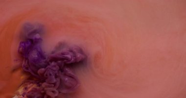 Mürekkep suyu. Boya karışımı. Odaklanmamış pembe turuncu renkli duman girdap dokusu sıvı sıvısı soyut sanat arka planına yayılıyor.