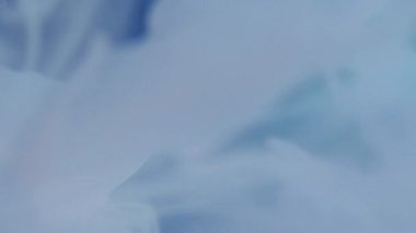 Boya sıçraması. Renk akışı. Odaklanmamış mavi damlalar soyut sanat arka planında parlayan sıvı sıvı mürekkep dumanı bulutu.