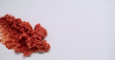 Dönen sis. Akış yayılıyor. Odaklanmamış turuncu bronz boya soyut beyaz arka planda su buharı sıvısında kıvrılır..