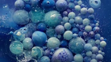 Akrilik daire. Yağ kabarcıkları. Mavi boya damlaları küçük parçacıklarla renkli sıvılarda akar. Yaratıcı sıvı karışımı soyut arka plan köpük yüzeyi.