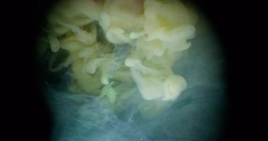 Duman patlaması. Haze girdabı. Soyut sıvıda sarı sisli akış mürekkebi. Siyah arkaplanda fantezi bulanık renk damlası karışımı.