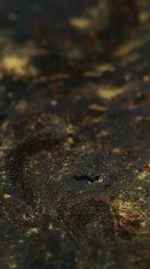 Dikey video. Altın akış. Parıltı selleri. Bakır akıntıyı kaplayan tuhaf kıvılcımlar saçan parlak metal tozlar. Değiştirilebilir sanat karışımı dekoratif lüks arka plan.