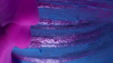 Dikey video. Duman boyası. Emülsiyon damlası. Pembe mor duman soyut mavi küre akıyor, parıldıyor, çizgili yüzey, su çözünmüş arka plan..