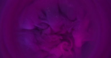 Bulut mürekkebi. Parıldayan sis. Parlak duman emülsiyonu renk pigmentini yuvarlak bulanık çerçeve arka planında harmanlıyor. Pembe mor spiral soyut simli sihirli akış.