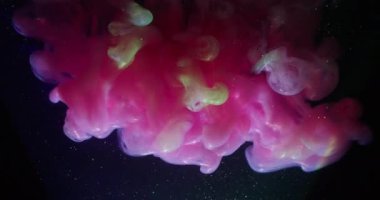 Renkli sis. Parıldayan dalga. Neon parlak boya sisi suda çözülüyor. Siyah arkaplan parlaklığında pembe yeşil duman soyut bulanık karışımı.