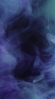 Dikey video. Buhar girdabı. Mürekkep suyu karışımı. Mavi mor renk patlama dumanı yüzen doku dalgası hareket soyut arkaplan yayıyor.