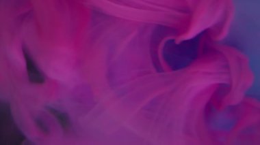 Dikey video. Mistik duman. Hipnoz sıvısı. Pembe mor kıvrımlı boya cam üzerinde süzülüyor mavi kristal elmas su çözülmüş soyut arkaplan.