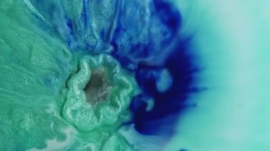Işıldayan akış. Sıvı patlaması. Mavi mor turkuaz boyayı dolduran gümüş rengi kara delik. Mermer karıştırıcı ışıltılı pigment soyut arkaplan.