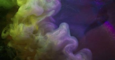Sis boyası. Parıltı akıyor. Siyah arka planda renkli spektrum dumanı karışım akışı. Işıldayan sarı mor boya soyut girdap.