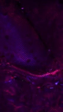 Dikey video. Islak pırıltı. Uzaylı dokusu. Hasarlı yüzeyde yanardöner taşma. Hipnotize edici renk yanardağıyla parıldayan sıvı..