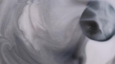 Boya dalgası. Grunge akıntısı. Mor ıslak arka plan yüzeyine gri mermer mürekkep yayılmış. Monokrom siyah sızıntıya odaklanmış..