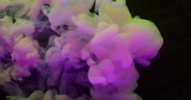 Pigment damlası suyu. Boya patlaması. Pembe sarı neon boya çözünürlüğü. Soyut bulanık siyah arkaplanda renkli buhar karışımı.