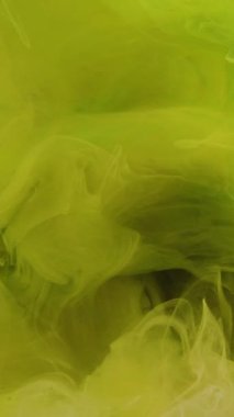 Dikey video. Duman girdabı. Boya bulutu. Neon sarısı yeşil mürekkep karışımı su sıçrama deseni soyut sanat arkaplanı gibi rüya..