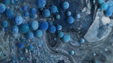 Sanat sıvısı. Kabarcık mürekkebi. Yüzen mavi jel damlalarını karıştıran mistik mermer gri siyah su. Dalgalı akan bulanık renkli soyut arkaplan.