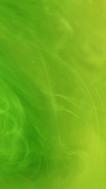 Dikey video. Renk dumanı. Buhar buharı. Odaklanmamış parlak yeşil boya bulutu mürekkep girdabı sıçraması soyut sanat arka planında hareket ediyor.