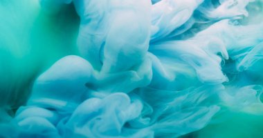 Duman akıntısı. Boyayla boyanmış. Yeşil akımda mavi sıvı boya patlaması. Sanat dumanı dalgası soyut bulanık arkaplan renkli pigmentleri karıştırıyor.