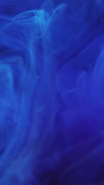 Dikey video. Rüya bulutu. Parlak renk. Odaklanmamış parlak mavi sıçrama boyalı sisli sihirli duman soyut modern sanat arka planında ilerliyor.