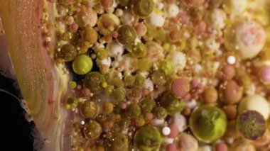 Jel damlası. Köpüklü sıvı. Renkli sıvı karışımı köpürüyor. Dalgalı, sarı, kahverengi mermer, soyut arka plan parıldıyor..