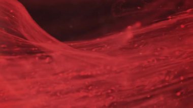 Görüntü sıvısı dökülüyor. Su damlayan boya. Odaklanmamış kırmızı renk parlaklık sıvısı soyut sanat arkaplanı üzerine duman dokusu dalgası düşürür..