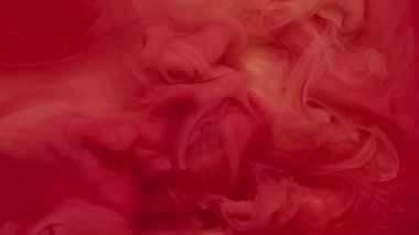 Su altı boyası. Sıvı mürekkep. Odaklanmamış kırmızı pembe sis dokusu su sıçratır girdap gibi akan sıvı soyut sanat arkaplanı üzerinde dalgalanır..