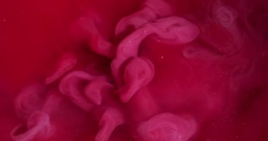 Duman patlaması. Duman boyası. Kırmızı köpüklü suda pembe dalga pigmenti döküldü. Renk akışı çözünmüş boya soyut kıvrım arkaplanını çözer.
