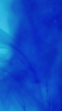 Dikey video. Boya suyu karışımı. Soyut sanat. Odaklanmamış parlak mavi çok renkli ışıltılı mürekkep lekeli bulut dumanı arka planda hareket ediyor..